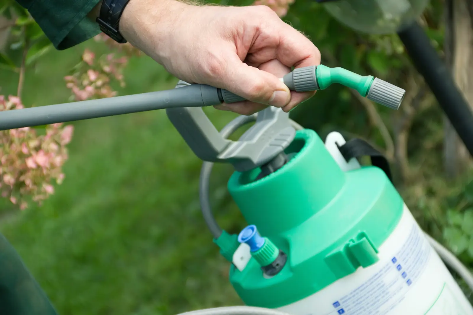 Hicks Pest Control technician treating a yard