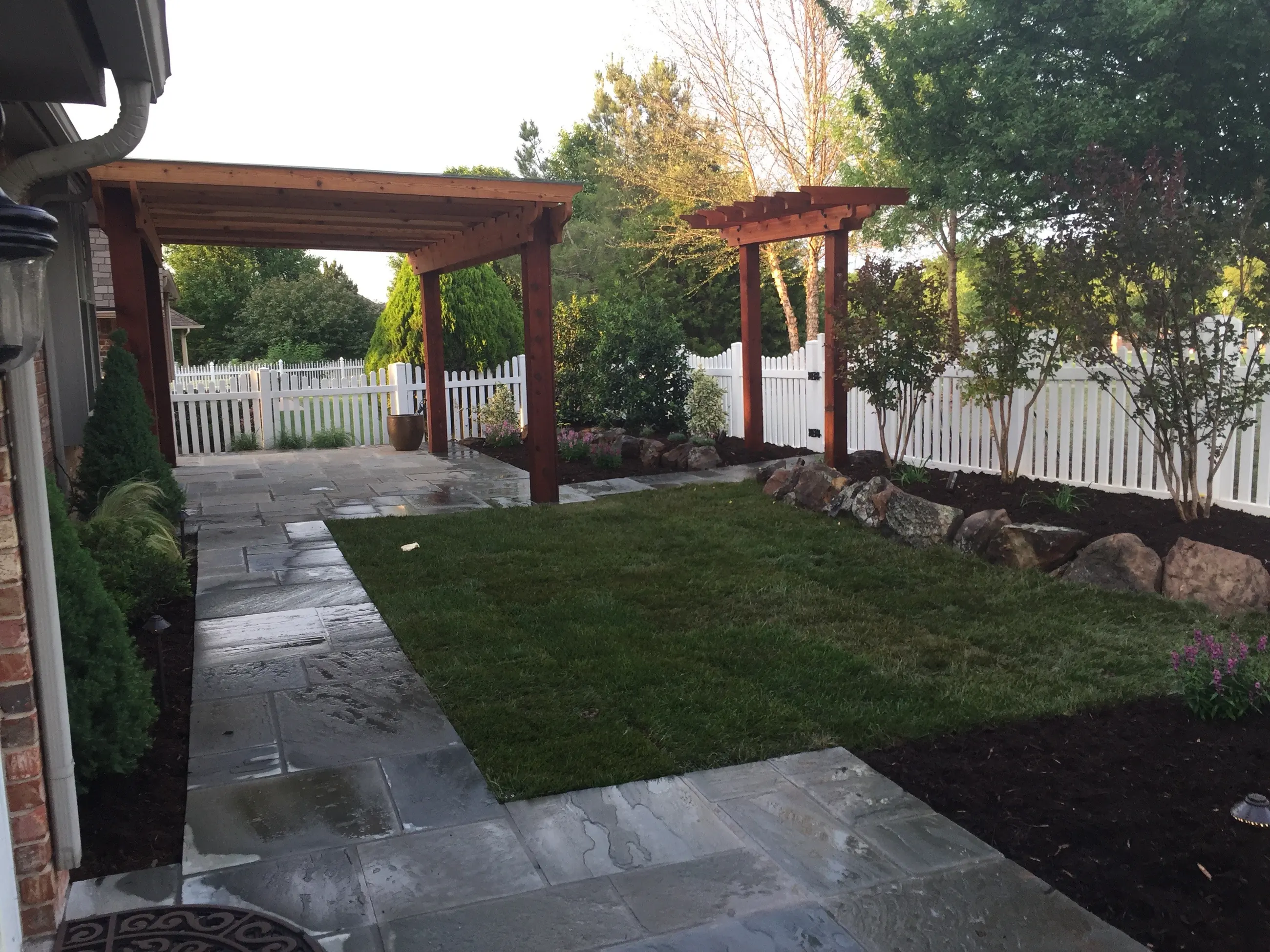 Stone patio and cedar pergola built by Giant Landscape